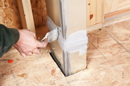 A man sealing an air duct in a Sacramento, CA home